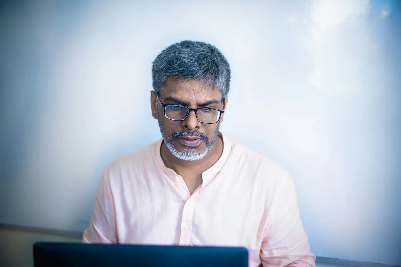 A founder reading on his laptop