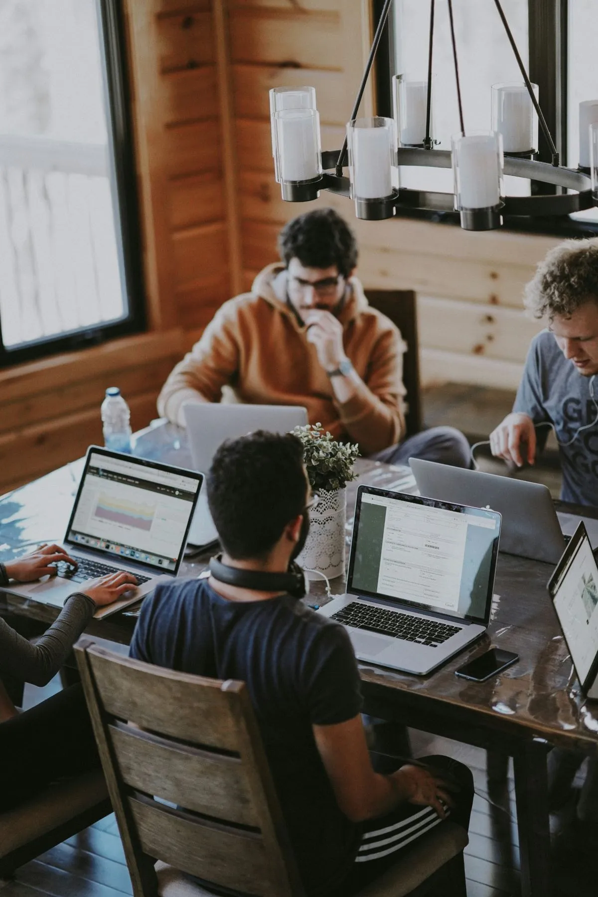 A small team working on laptops around a table
